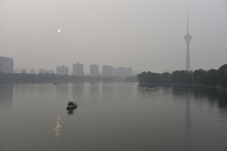 10月19日，北京陷入一片雾霾之中，从玉渊潭公园看中央广播电视塔和太阳。   ICphoto 图